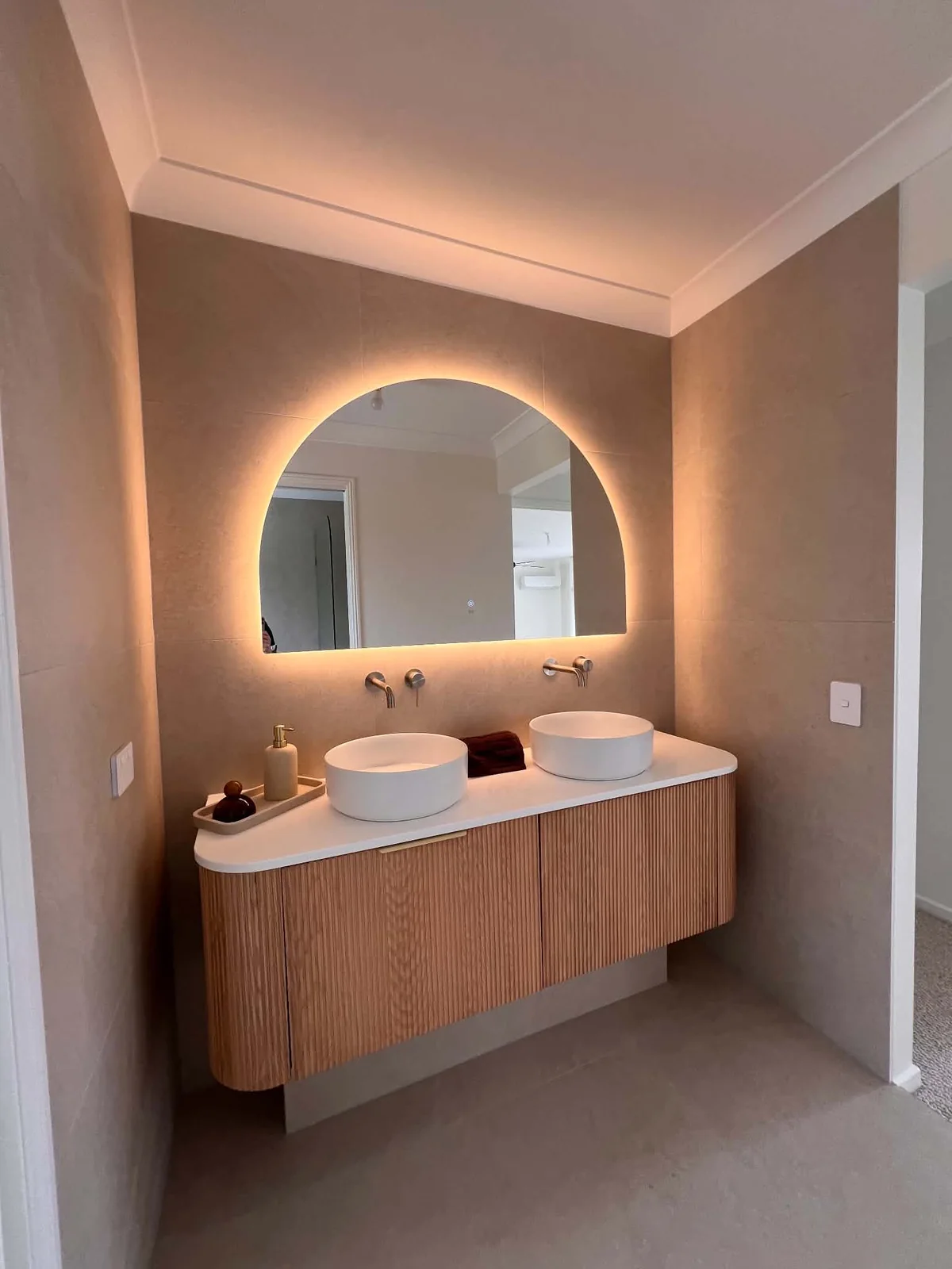 Fluted timber vanity with arched backlit mirror