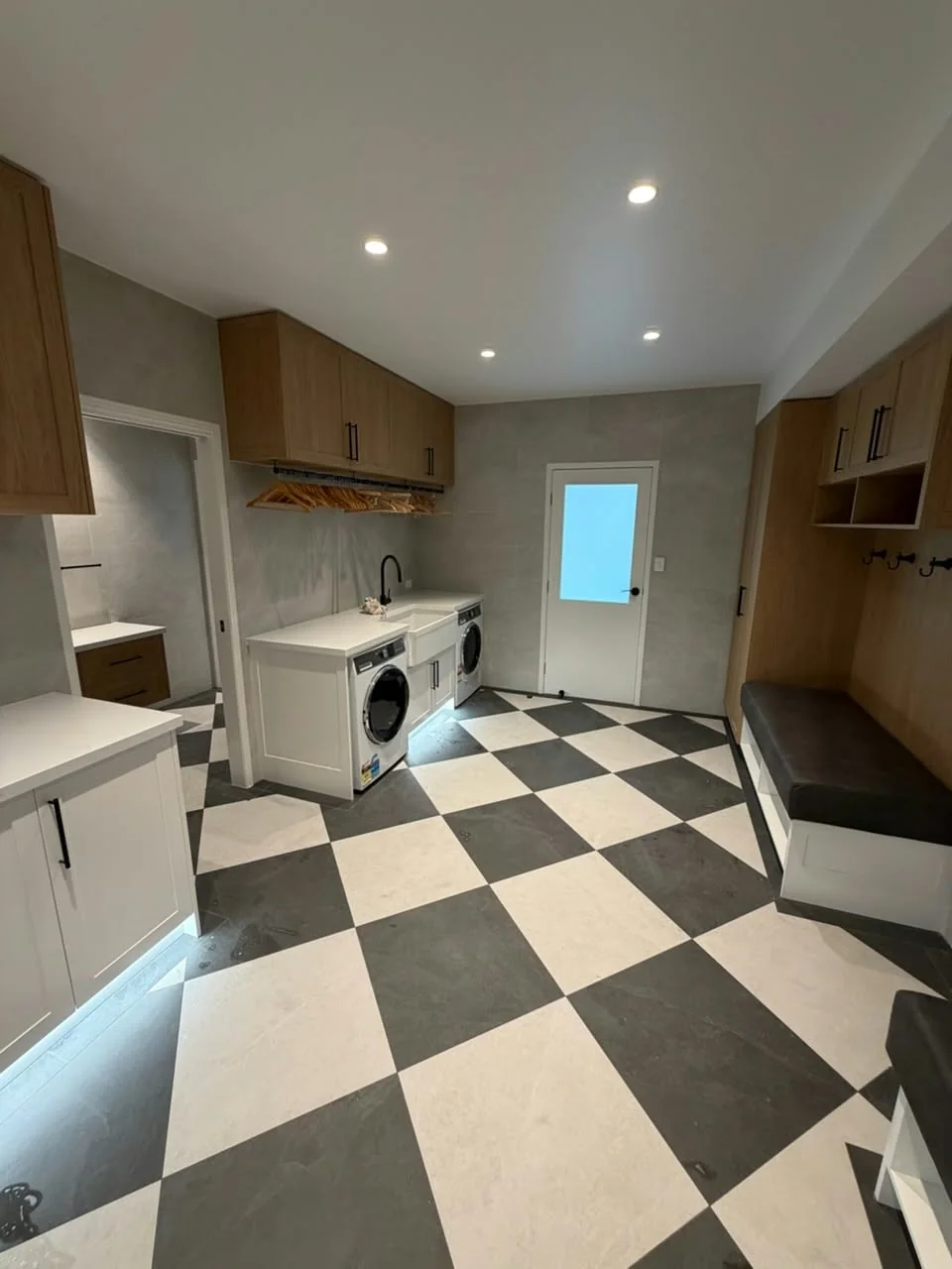 Laundry with black and white checkerboard floor tiles