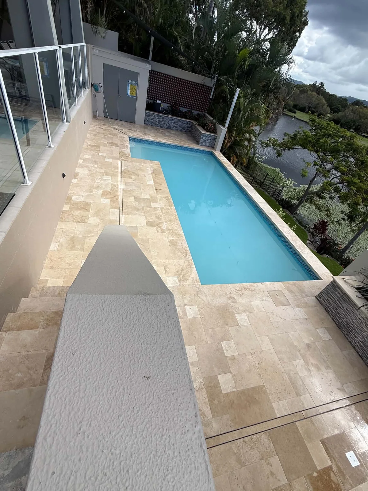 Travertine pool surround with mosaic waterline
